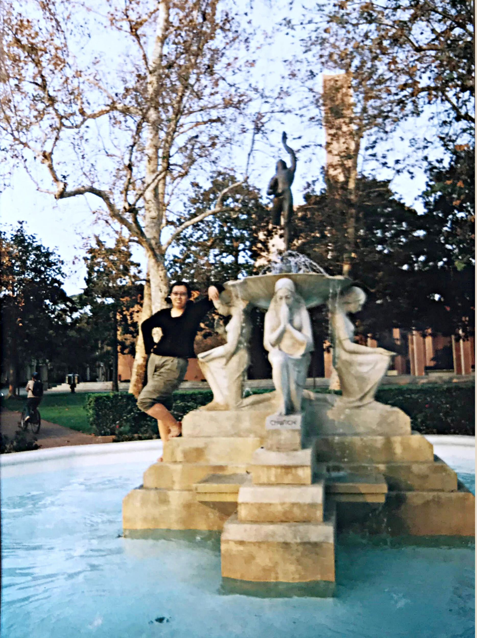 Sandra biographical image from USC (c. 2002-2005) standing barefoot inside a fountain among the water sculpture figures.